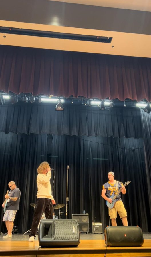  Lights flood the room, the sound of the bass vibrates the ground, the seats are filled with starstruck students. During lunch on October 15, 2022, Steinbrenners auditorium was anything but quiet as the band “Requires Action” took the stage by storm. Photo courtesy of Saule Kondra.