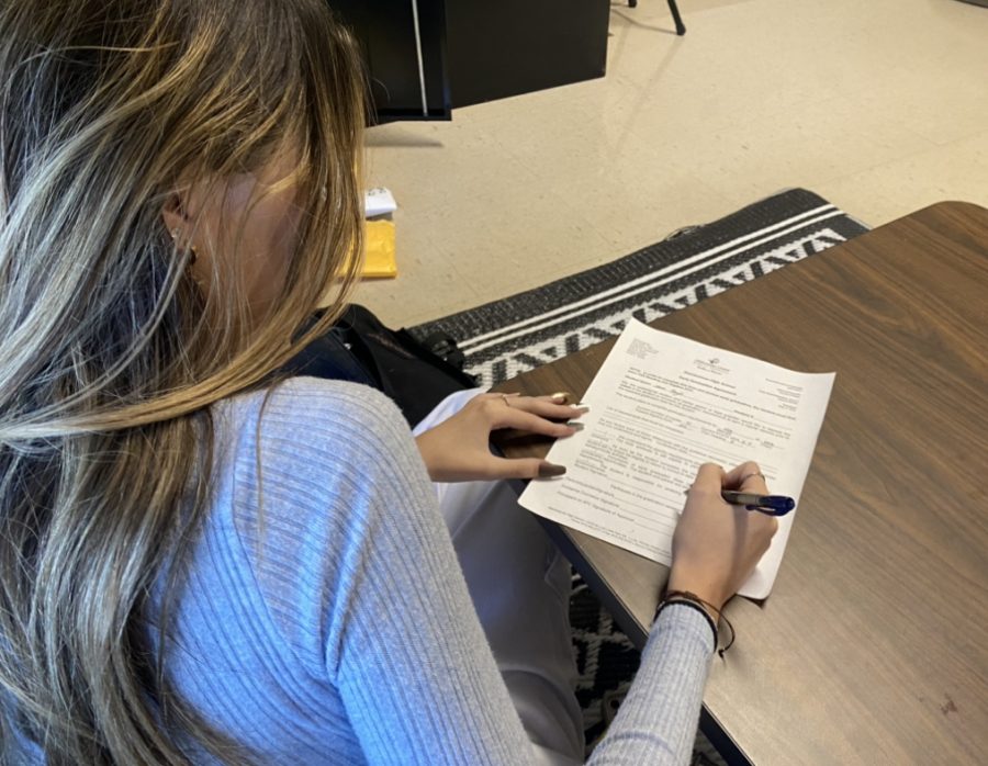 Olivia Pages, a senior at Steinbrenner, completes a graduating early agreement paper. Filling this form out is one of the first steps to being able to graduate early. Photo courtesy of Ava Combs. 