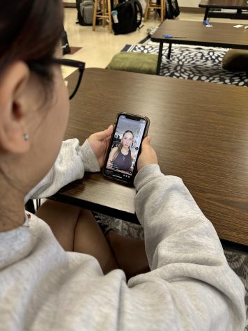  Longtime fan Olivia Montgomery watches one of Earle’s most recent TikTok’s. Earle has been on TikTok since 2020 but gained the majority of her followers within the past months through viral videos. Photo courtesy of Alyssa Galang.  