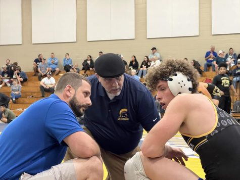 Coach Paul Noble (center) checks up on senior Garret Krusol (right) after a rough match. Before the semifinal match, Noble was preparing his players for a touch match up with long, endurance-focused practices. Photo courtesy of Saule Kondra. 