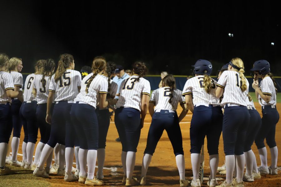 Girls+softball+team+on+the+home+plate+with+their+coach+after+the+game.+Photo+courtesy+of+Malia+Kirschman+
