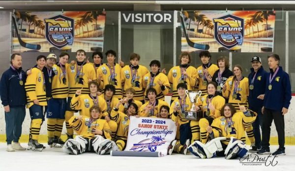 Proud Steinbrenner hockey players and coaches huddle together to take a picture after winning the state title. The team had been preparing for this moment for the entire season consistently practicing improving their skills as a team. Photo courtesy of Amber Pruitt.    