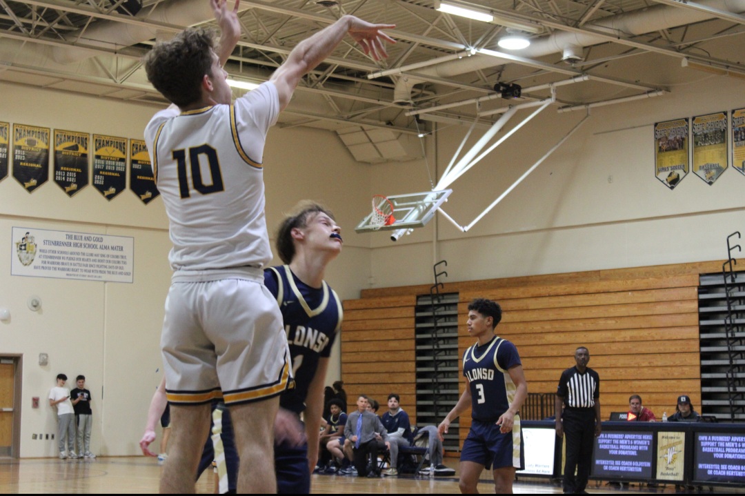 Tyler Goggan is shooting a three-point shot to hopefully get the Warriors a win. The team along with Goggan have all pushed through the game, but it eventually led them to a loss. This loss will then help the warriors learn from their mistakes and get a win in the next game. 