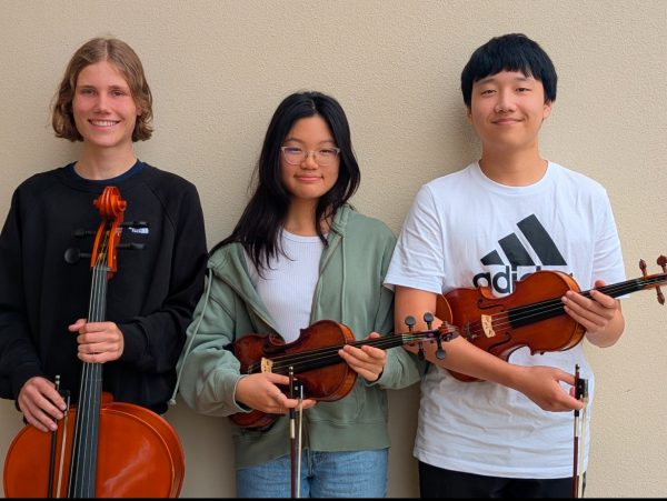 Carl Arnold, Leah Wan, and Andy Wu stand proudly with their instruments after hearing that they have qualified for the Florida Music Education Association State Conference. These students have been playing their instruments for numerous years to perfect their skills. Photo courtesy of Andrea Szarowicz. 