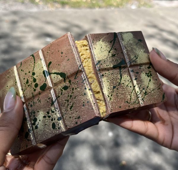 The famous Dubai chocolate bar, covered with golden glitter and green food coloring on a milk chocolate covering, stuffed with pistachio and tahini filling. The Schokolade Chocolate Factory in St. Petersburg has been serving fresh gourmet chocolate since 2004. Photo courtesy of Ademy Malave.