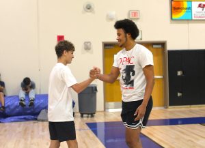 (Left to Right) Evan Falco (9th), Titan Norris(12th). A Freshman and Senior Share a bond over basketball. After this handshake, the duo started a handshake. 
