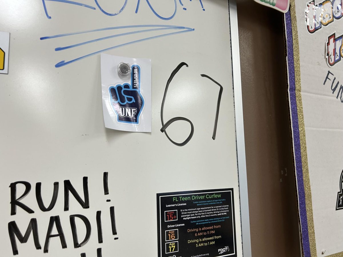 The photo above is of the 6 7 meme written on Coach Baldwin’s Driver’s Ed classroom whiteboard by an unknown student. The 6-7 meme has been gaining popularity among teenagers.  Photo courtesy of Seth Demetroulis