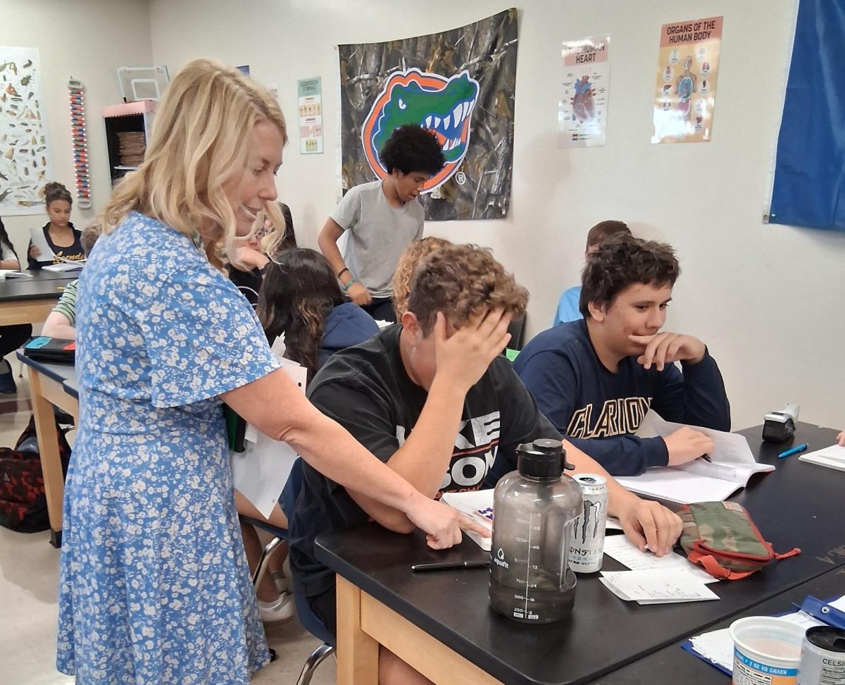 Mrs. Roy helps one of her students with his notes. Now that the first quarter has ended, it’s time to work even harder to stay on top of work. Photo courtesy of Ash Podosek. 