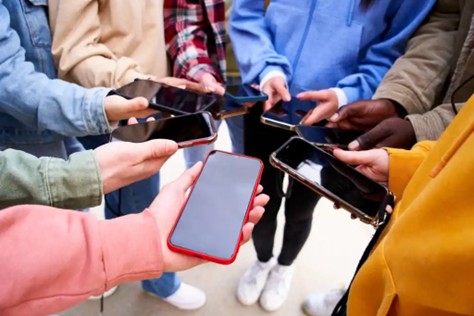 Students are collectively spending time on their phone at school, rather than putting them away in the learning environment. This is a highly debated issue, if students should have free access to their phones during school hours or not. Photo courtesy of Asheville Recovery Center.
