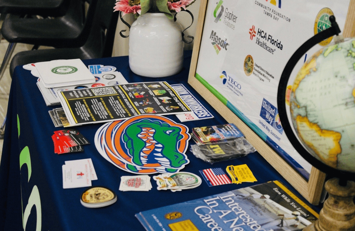 A display table at a lunch and learn with flyers and stickers promoting colleges and information. Students were able to ask questions and receive help regarding education and college. Photo courtesy of Simmi Chaube. 