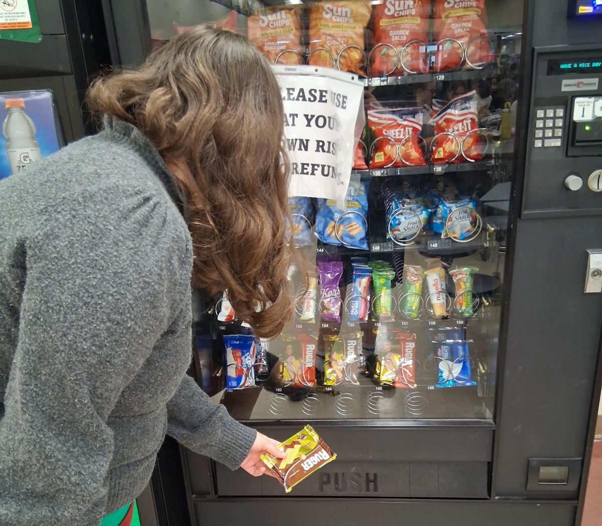 Sohpomore Ashlyn Marshall retrieving her snack from the vending machine. The vending machine had a bit of a line that day. Photo courtesy of Ash Podosek. 